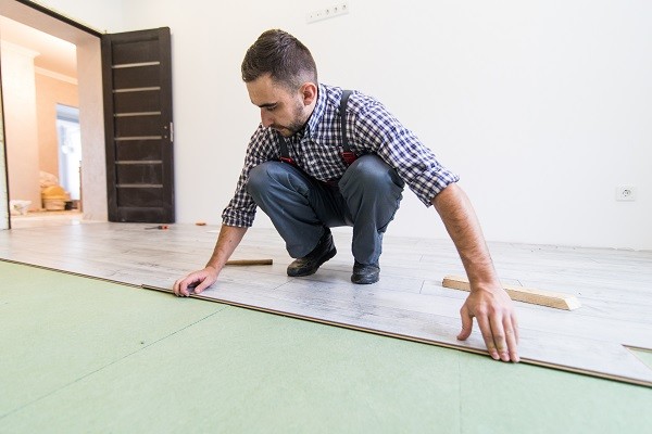 close-view-young-worker-laying-floor-with-laminated-flooring-boards.jpg